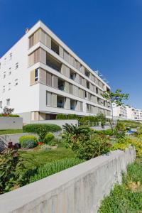 a white apartment building with a garden in front of it at A Riduli in Split