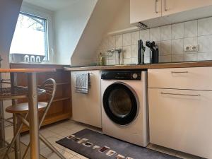 a kitchen with a washing machine and a table at Modernes Apartment 9 in Bochum in Bochum