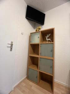 un estante de libros con TV en la pared en Modernes Apartment 9 in Bochum, en Bochum