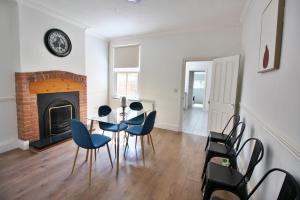 a dining room with a table and chairs and a fireplace at Exceptionally Stunning Four Bed Terraced House With Two Bathrooms- Recently Renovated in Spon End