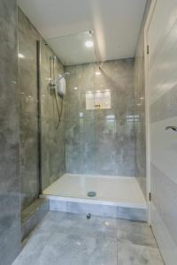 a bathroom with a shower with a glass door at Hayes Home - Easy links to LHR and London in Northolt