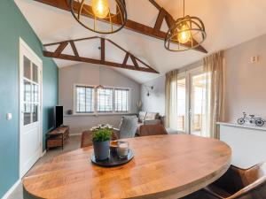 a dining room and living room with a wooden table at Charming house with garden in rural area Hellendoorn in Hellendoorn