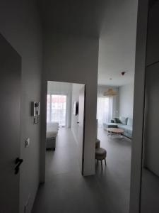 a hallway leading to a living room with a couch at Apartament na wydmie in Mrzeżyno