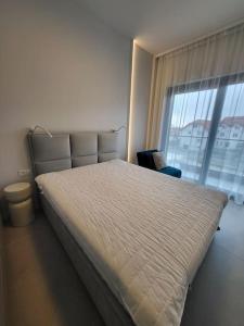 una camera da letto con un grande letto con una grande finestra di Apartament na wydmie a Mrzeżyno