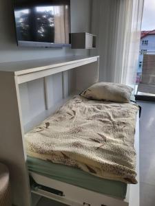 a small bed in a room with a window at Apartament na wydmie in Mrzeżyno