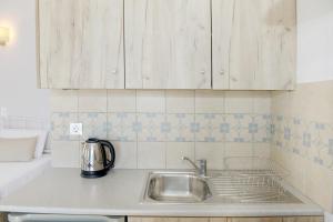 a kitchen counter with a sink and cabinets at Spitakia in Halki +37 photos
