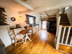 a living room with a table and a kitchen at Rising Sun Hotel in Lynmouth