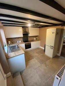 a kitchen with a white refrigerator and a stove at Rustic Retreat cottage in Thirsk
