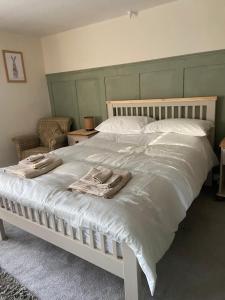 Un dormitorio con una cama blanca con toallas. en Rustic Retreat cottage, en Thirsk