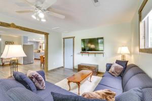 a living room with a blue couch and a dog laying on the floor at Cottage with Yard and Grill about 21 Mi to Hocking Hills! in Nelsonville