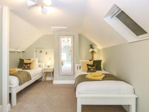 1 dormitorio con 2 camas y espejo en West Farm, en Great Yarmouth