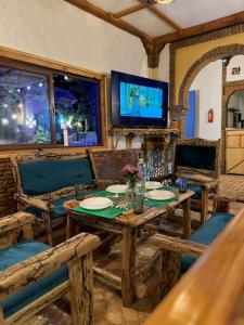 alberegue Rustica في شفشاون: غرفة طعام مع طاولة وكراسي وتلفزيون