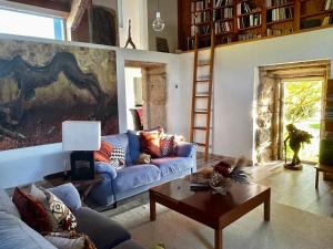 uma sala de estar com um sofá azul e uma mesa em Casa da Fontiña em Tortoreos