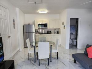 a kitchen and dining room with a glass table and chairs at Happy Place in Orlando