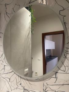 um espelho circular numa parede com uma cozinha em Ginevra Home Bologna -Self check-in em Bolonha