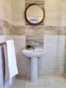 a bathroom with a sink and a mirror at House At Eight in Jwaneng