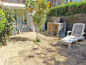 een stoel in een tuin naast een tafel bij Le Sentein, T2, centre, parking, jardin, 2 personnes in Luchon