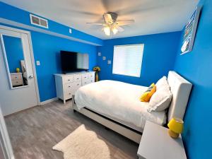 a blue bedroom with a bed and a ceiling fan at Modern Beachside Bliss: 2 Bed/2 Bath Condo Haven in Rehoboth Beach