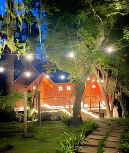 una casa con luces en el patio por la noche en Cabana Suspensa na Natureza - Região Turística en Campos do Jordão