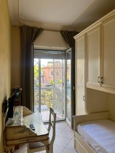 um quarto com uma cama, uma mesa e uma janela em Specter Guesthouse em Nettuno