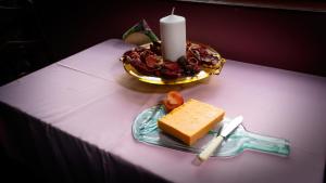 una vela y un plato de queso sobre una mesa en Cradog B&B. en Kilkenny