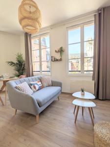 een woonkamer met een bank en een tafel bij Le Perchoir - Studio vue imprenable - Hypercentre in Rouen