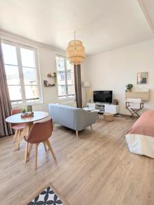 een woonkamer met een bank en een tafel bij Le Perchoir - Studio vue imprenable - Hypercentre in Rouen