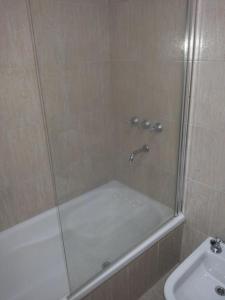 a shower with a glass door next to a sink at San Isidro in Viedma