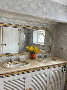 a bathroom with two sinks and a mirror at Casa da Lagoa in Évora