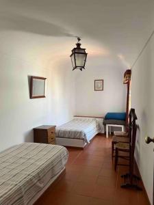 1 dormitorio con 2 camas, silla y lámpara en Casa da Lagoa, en Évora