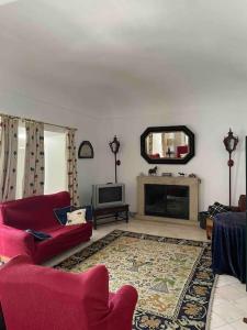 a living room with a red couch and a television at Casa da Lagoa in Évora