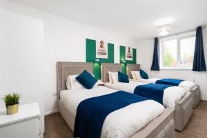 3 camas en una habitación de color azul y blanco en Majestic Manc Gem - Pool Table - Parking - Etihad, en Mánchester