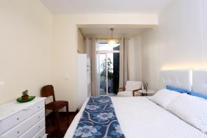 フンシャルにあるRochinha Cozy Homeのベッドルーム1室(青と白のベッドカバー付)