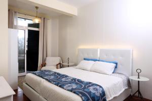 フンシャルにあるRochinha Cozy Homeの白いベッドルーム(大型ベッド1台、窓付)