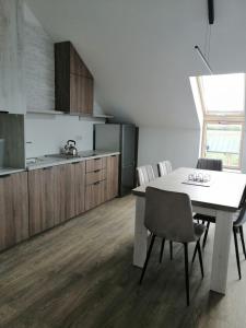 uma cozinha com mesa e cadeiras num quarto em Rybitwy Residence em Mielno