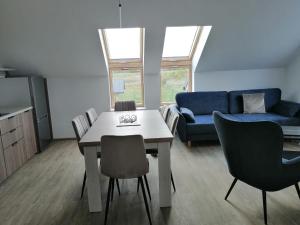 uma sala de estar com uma mesa e cadeiras e um sofá em Rybitwy Residence em Mielno