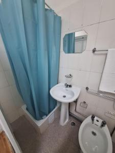 baño con lavabo, aseo y cortina de ducha azul en Residencial Ideal, en Lisboa
