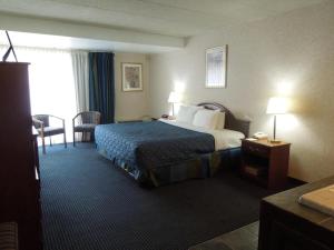 una camera d'albergo con letto, tavolo e sedie di Red Carpet Inn & Suites a Philadelphia