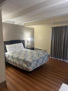 um quarto de hotel com uma cama e uma janela em Red Carpet Inn & Suites em Filadélfia