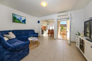 een woonkamer met een blauwe bank en een tafel bij Apartments Filipovic in Makarska