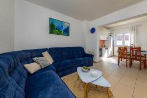 a blue couch in a living room with a table at Apartments Filipovic in Makarska