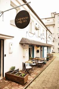 a sign for a restaurant with a table and chairs at Schöndorf Hostel - virtual reception in Bratislava