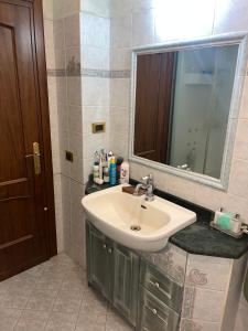 uma casa de banho com um lavatório e um espelho em Specter Guesthouse em Nettuno