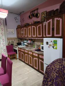 a kitchen with wooden cabinets and a white refrigerator at Kalys House in Kavála