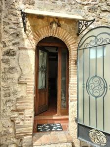 una entrada a una casa de piedra con puerta de madera en La Piazzetta - Locazione turistica nel centro storico di Acquasparta, en Acquasparta
