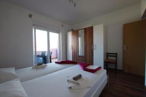 1 dormitorio con 1 cama blanca grande y toallas. en Apartments Branko, en Selce