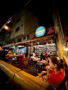 un grupo de personas sentadas en un restaurante por la noche en VA Apart Hotel Savassi, en Divinópolis