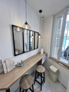 a bathroom with a vanity with two stools and a mirror at Cosy Studio *Vieux-Port* in Marseille