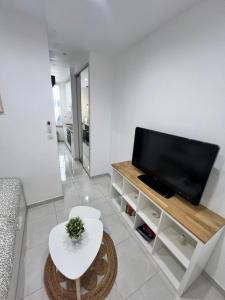 a living room with a flat screen tv and a table at Cosy Studio *Vieux-Port* in Marseille