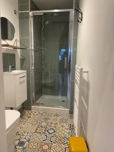 a bathroom with a shower and a toilet and a sink at Studio cosy in Ham